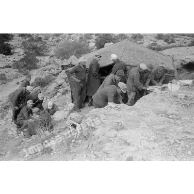 Des soldats allemands travaillent et discutent près d'une tente.