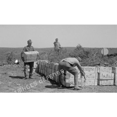 Des soldats assurent la manutention de caisses d'approvisionnement.