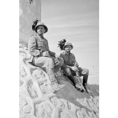Deux Bersaglieri assis devant le mur d'un fort.