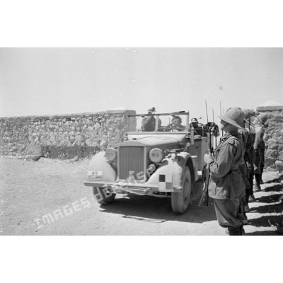 La voiture Kfz-12 du général Erwin Rommel passe devant une rangée de Bersaglieri qui présente les armes.