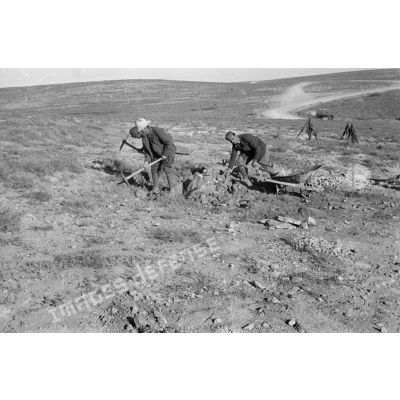 Des soldats italiens extraient des pierres (des pioches) qui seront utiles pour la réfection d'une route.