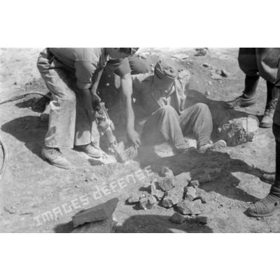 Les soldats italiens creusent un trou à l'aide d'un marteau-piqueur.
