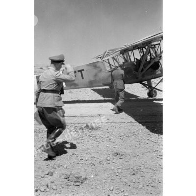 Le maréchal (Generalfeldmarschall) Erwin Rommel se dirige vers un avion Fi-156 Storch et y monte en compagnie de Gause.