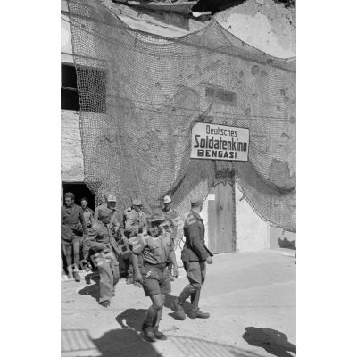 Des soldats allemands et des soldats et marins italiens sortent du cinéma (Soldatenkino) de Benghazi (Bengazi).