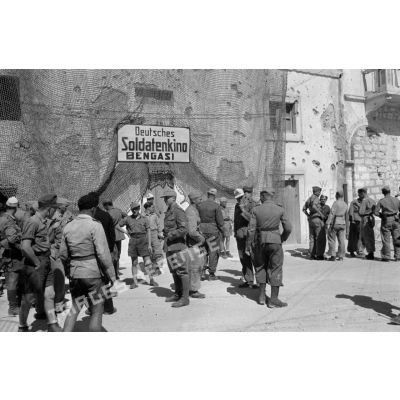 Des soldats allemands et des soldats et marins italiens sortent du cinéma (Soldatenkino) de Benghazi (Bengazi).