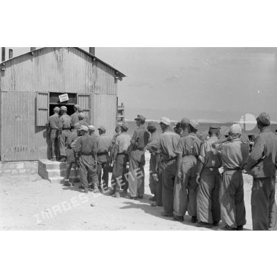 Des soldats font la queue pendant une distibution de nourriture.