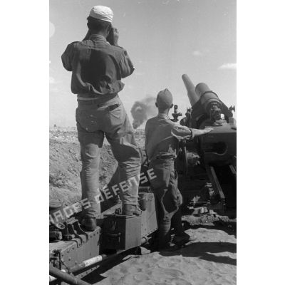Une batterie de canons 10 cm schwere Kanone 18 règle son tir pour soutenir les blindés.