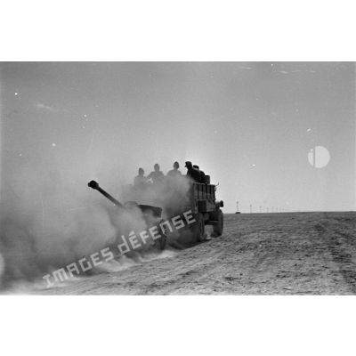 Dans un nuage de poussière, un camion Ford 3T d'origine britannique tracte un canon antichar (5 cm PaK 38).