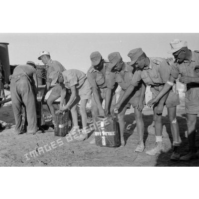 Des soldats remplissent des jerrycans d'eau potable.