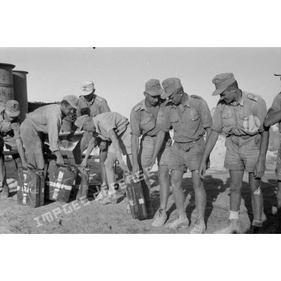 Des soldats remplissent des jerrycans d'eau potable.