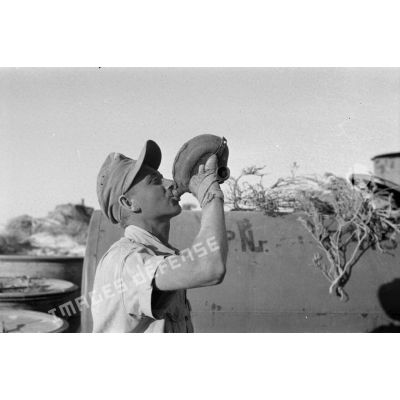 Un soldat allemand boit à une gourde certainement pour tester la potabilité de l'eau désalinisée.
