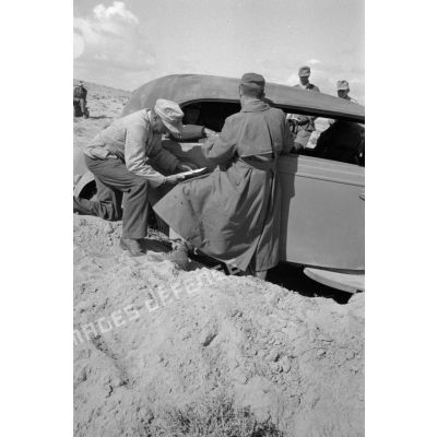 Rommel assis dans une voiture Horch Commandeur parle avec des officiers. (Oberst Bayerlein et General der Panzertruppe Wilhelm Ritter von Thoma)