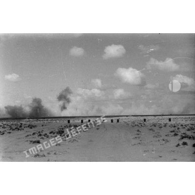 Impacts de l'artillerie ou  véhicules en flamme dans le désert.