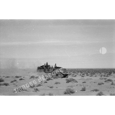 Un semi-chenillé SdKfz-7 qui tracte un canon de FlaK de 2 cm passe dans le désert.