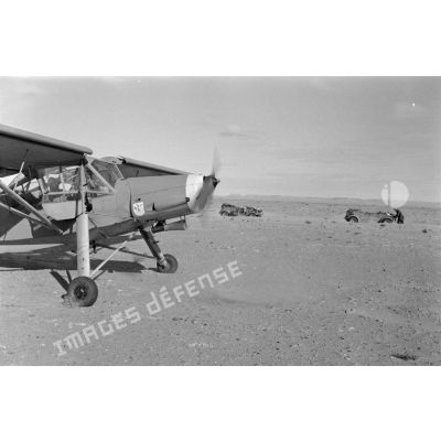 Un avion Fieseler Storch posé près de la colonne; on reconnaît le scorpion du Sonderkommando Dora.