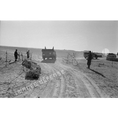 La colonne de véhicules dépasse un point de contrôle occupés par les troupes italiennes sur une piste.