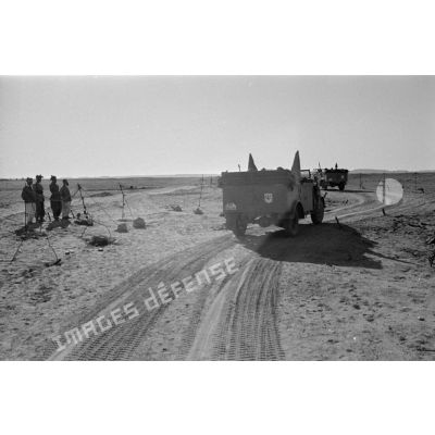 La colonne de véhicules dépasse un point de contrôle occupé par les troupes italiennes sur une piste.