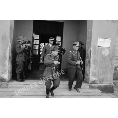 Les maréchaux Rommel et Bastico quittent le Commando Distretto Militare Di Misurata, suivis par des officiers.