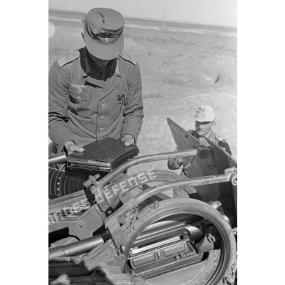 Un servant approvisionne un canon de DCA de 2 cm FlaK 38.