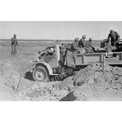 Le camion Ford 3T équipé d'un canon de 2 cm FlaK 38 quitte sa position de tir et regagne la piste.