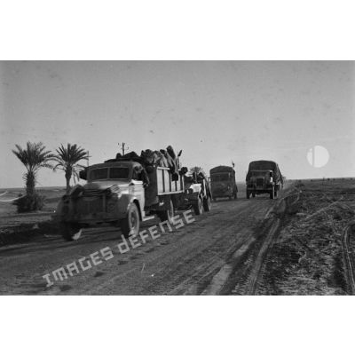 Une unité de FlaK se déplace an convoi sur une route. Elle est équipée de véhicules allemands et anglais.