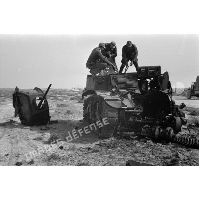 Des soldats allemands inspectent l'épave d'un char américain M3 Stuart détruit.