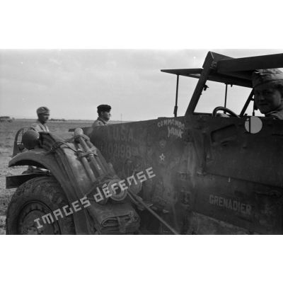 Avant d'un half-track américain (APC M2) capturé, un soldat allemand est au volant.