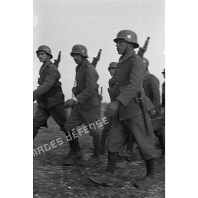 Gros-plan sur des volontaires défilant avec des mitrailleuses MG-34.