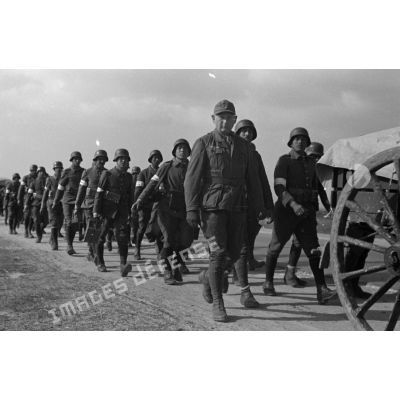 Les volontaires conduits par les cadres allemands suivis par les carrioles du train de combat et des mulets.
