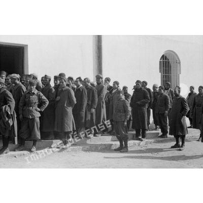 Des volontaires arabes dans les troupes allemandes patientent devant le magasin du corps pour percevoir un nouvel uniforme.