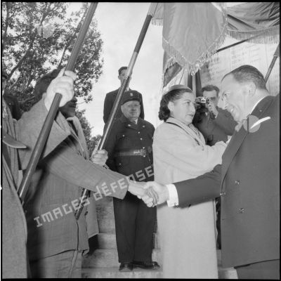 Poignée de main entre le gouverneur général d'Algérie Robert Lacoste et un porte-drapeau devant le monument aux morts d'Alger.