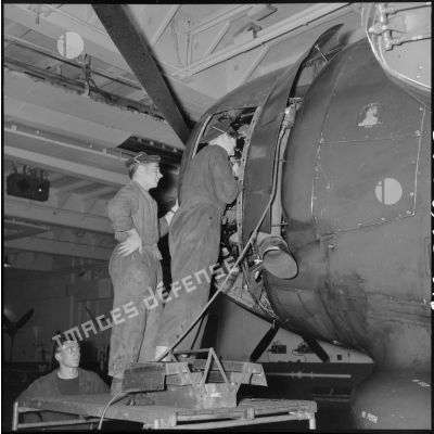 Maintenance du moteur d'un bombardier Grumman TBM-3S Avenger par des mécaniciens du porte-avions l'Arromanches lors d'un exercice en Méditerranée.