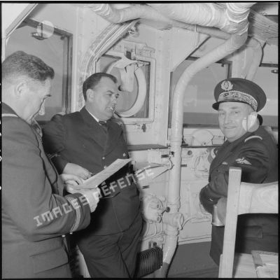 Discussion entre trois officiers supérieurs lors d'un exercice à bord du porte-avions l'Arromanches en Méditerranée.