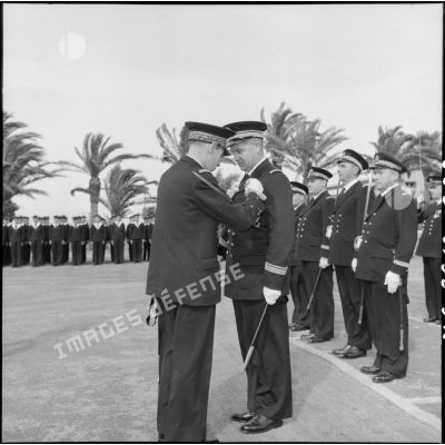 Décoration d'un capitaine de corvette par le vice-amiral d'Auboyneau, commandant des forces maritimes françaises en Méditerranée, au centre Sirocco.