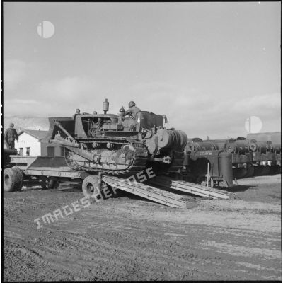 Remorquage d'un tracteur-niveleur Caterpillar par un soldat du 3 régiment étranger d'infanterie à Arris (Aurès).