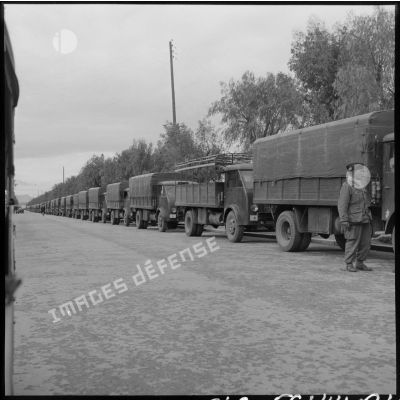 Convoi de camions militaires attendant les soldats du 19e bataillon de chasseurs à pieds devant la gare ferroviaire d'Oudja (Maroc).
