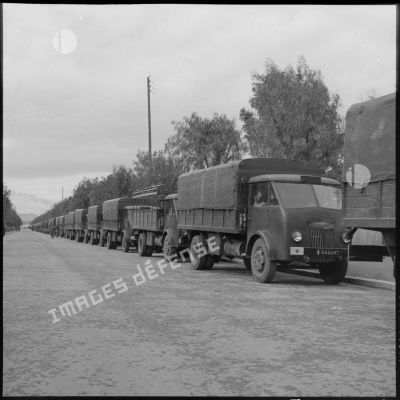 Convoi de camions militaires attendant les soldats du 19e bataillon de chasseurs à pieds devant la gare ferroviaire d'Oudja (Maroc).