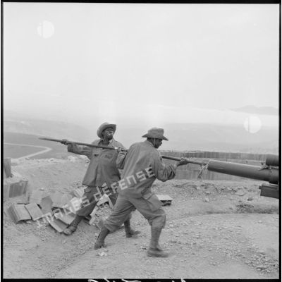 Nettoyage du fût d'un canon de 105 mm par des soldats du 5e bataillon du 10e régiment d'artillerie coloniale (RAC) après un tir opérationnel à Montagnac.