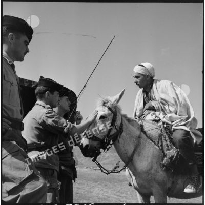 Conversation entre un cavalier kabyle et des soldats du 72e groupe d'artillerie à Zemmoura.