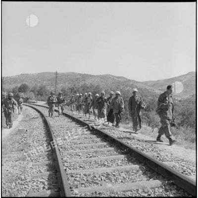 Progression du 1er bataillon du 5e régiment étranger d'infanterie  (REI) et de prisonniers le long d'une voie ferrée  dans le secteur de Nemours.