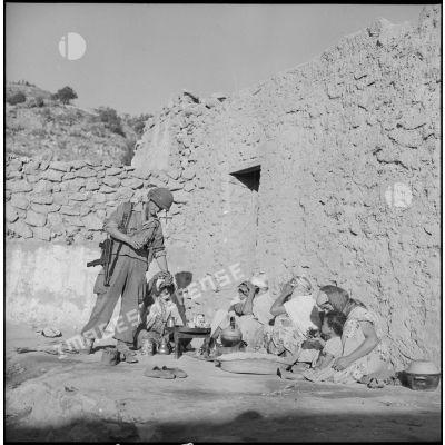 Soldat du 1er bataillon du 5e régiment étranger d'infanterie (REI) buvant une boisson préparée par les habitants d'un douar près de Nemours.
