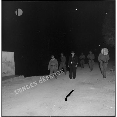Patrouille de nuit des appelés et rappelés de la section Algérie du Service cinématographique des Armées (SCA) dans les rues d'Alger.