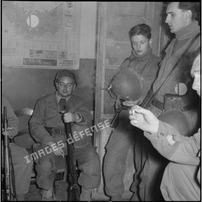 Attente de rappelés du Service cinématographique des Armées avant le départ en patrouille de nuit à Alger.