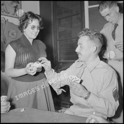 Demoiselle offrant une cigarette à un brigadier-chef du 117e régiment d'infanterie (RI) venant de débarquer à Alger.