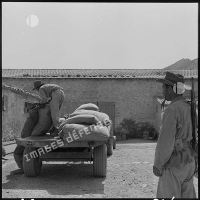 Des soldats déchargeant les sacs de céréales dans la région de Constantine.