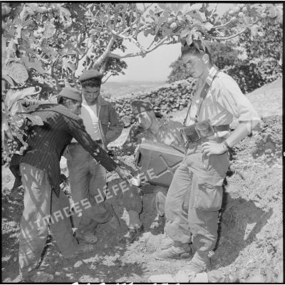 Des soldats du 2e régiment d'infanterie (RI) offrant de l'eau aux ouvriers algériens.