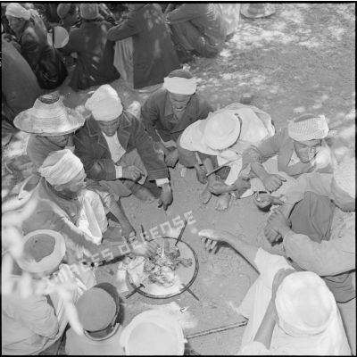 Les habitants de N'Daoud rassemblés autour des plats de couscous.