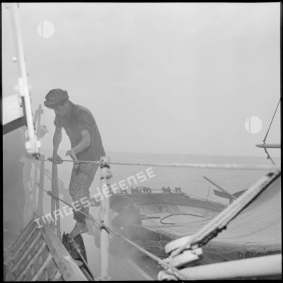 Un pêcheur montant à bord du patrouilleur côtier La Pique.