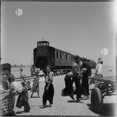 Passage d'un train devant des habitants de la région de Colomb Béchar.