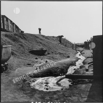 Des mineurs déchargent la cargaison du train à la mine de Colomb Béchar.